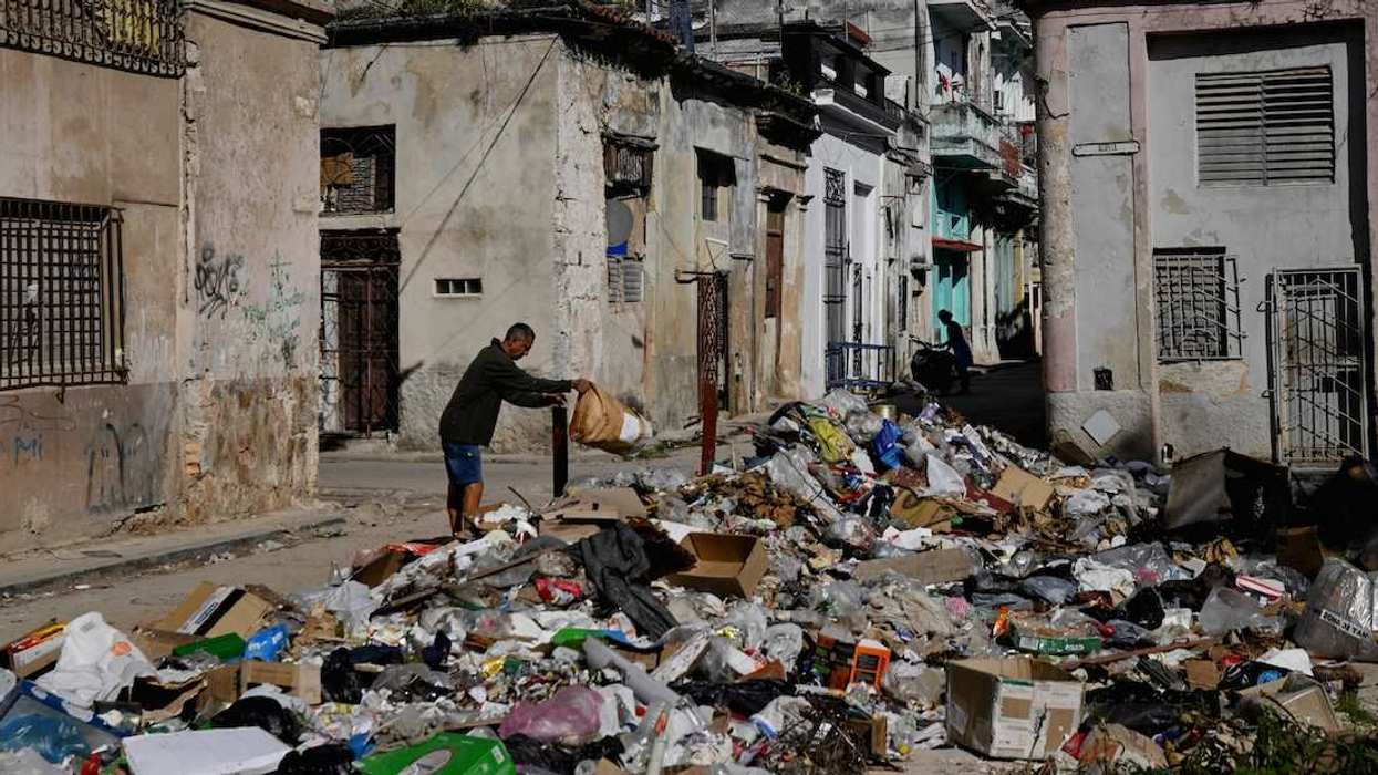 A man throws trash on a street in downtown Havana, Cuba, February 16, 2026.