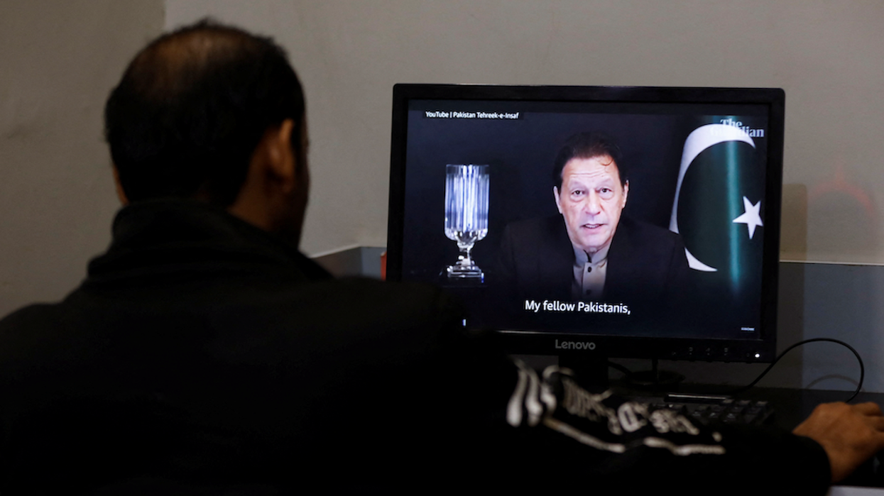 A man views a computer screen displaying an AI-crafted speech of former Prime Minister Imran Khan.