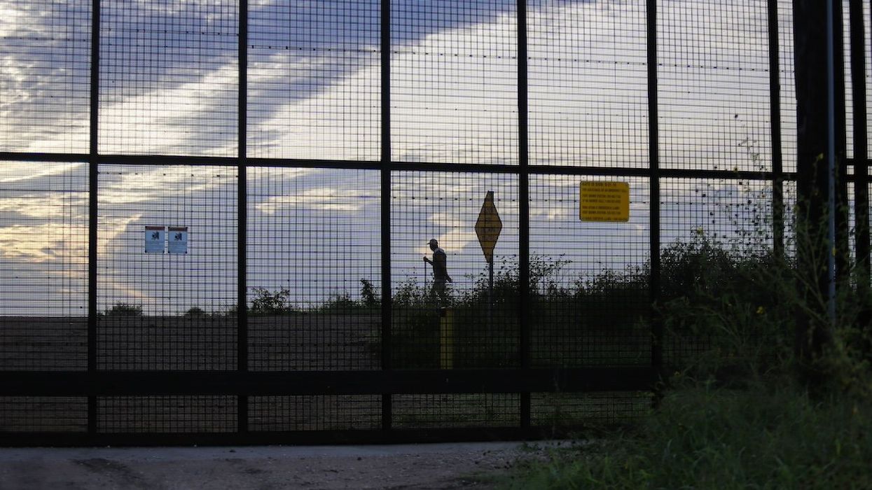 A man walks his dog on the Mexican side of a section of the U.S.-Mexican Border wall on Wednesday morning, September 7th, 2022, as seen from Cameron County, Texas
