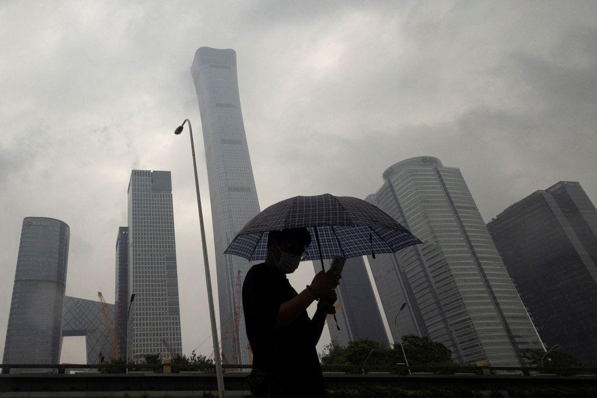 A man walks in the Central Business District on a rainy day, in Beijing, China, July 12, 2023.