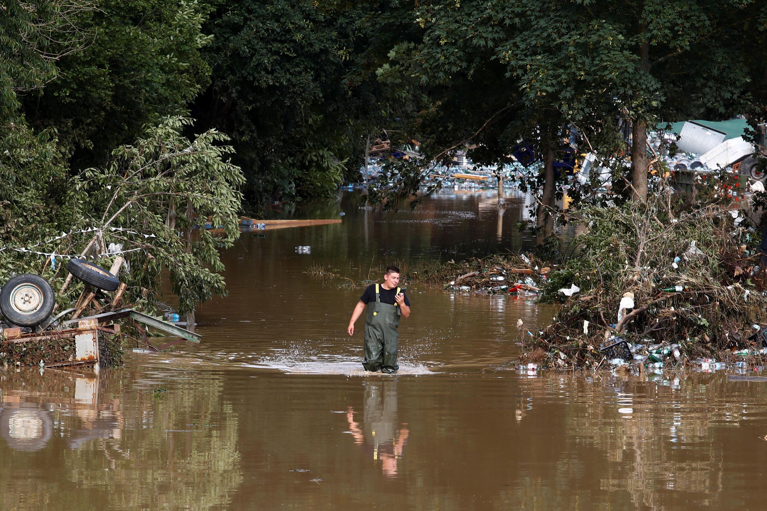 A man walks through the water in an area affected by floods following heavy rainfalls in Bad Neuenahr-Ahrweiler, Germany, July 15, 2021