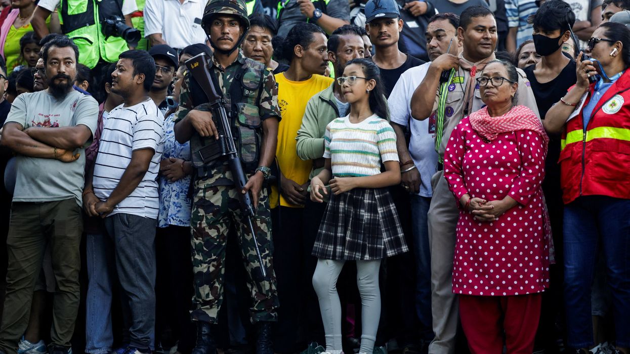 A member of Nepal army stands guard as people gather to observe rituals during the final day of Indra Jatra festival to worship Indra, Kumari and other deities and to mark the end of monsoon season,.