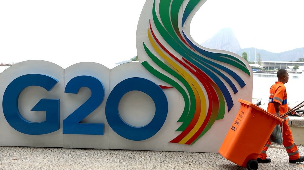 A member of the cleaning crew walks past a G20 Summit sign outside the Museum of Modern Art, the venue of the G20 summit, in Rio de Janeiro, Brazil, on Nov. 14, 2024.