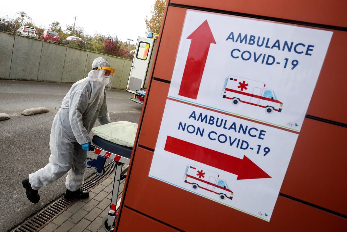 A member of the medical personnel wearing personal protective equipment (PPE) pushes a stretcher outside the CHR Sambre-Meuse hospital, amid the coronavirus disease (COVID-19) outbreak, in Auvelais, Belgium October 28, 2020