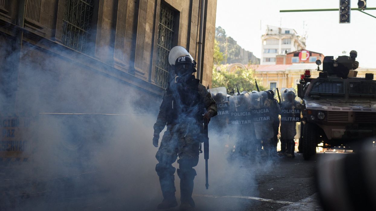 A member of the military police walks amid tear gas as Bolivia's President Luis Arce "denounced the irregular mobilization" of some units of the country's army, in La Paz, Bolivia June 26, 2024.