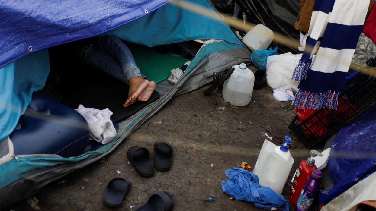A migrant woman seeking asylum in the U.S. rests inside a tent as she waits for her request to be processed, at a migrant encampment set in a public square in Reynosa, Mexico December 3, 2021.