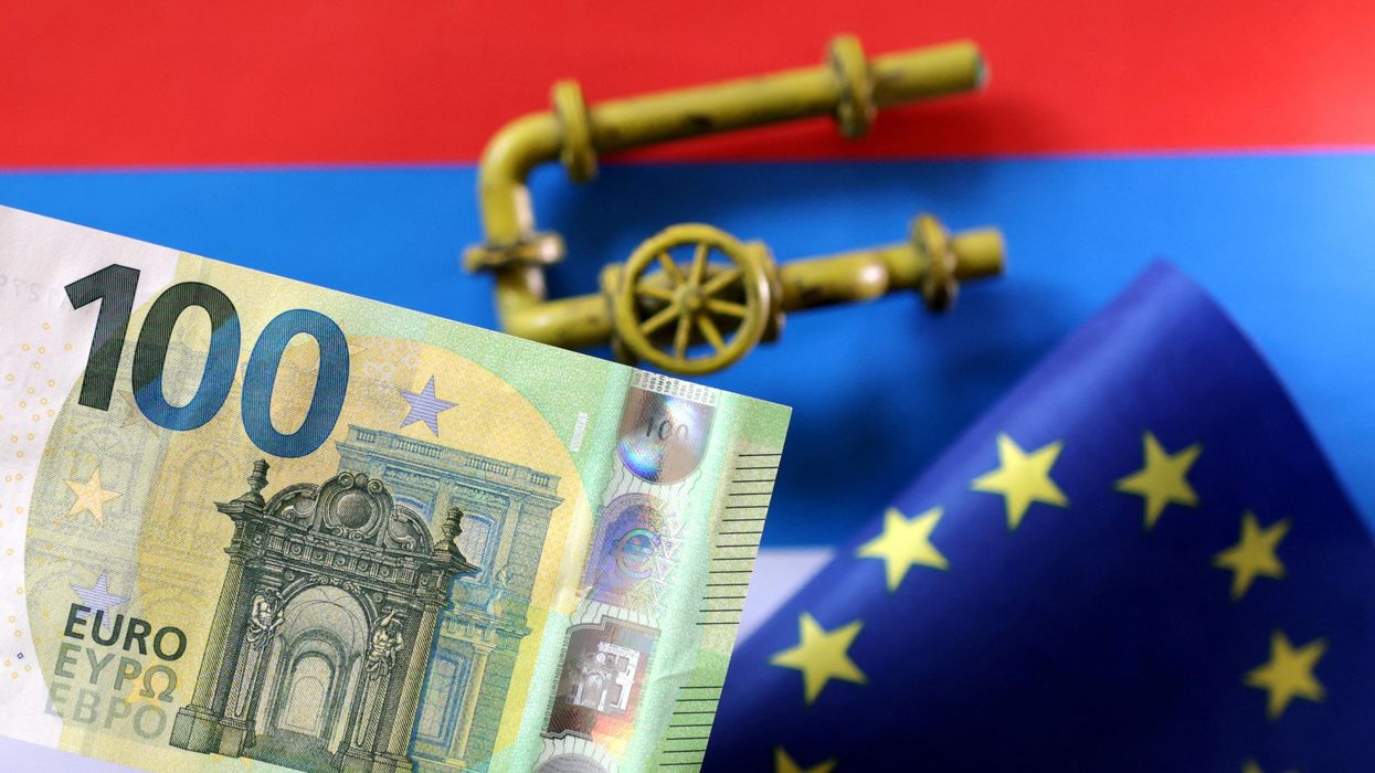 A model of a natural gas pipeline, a Euro banknote and a torn EU flag placed on a Russian flag.