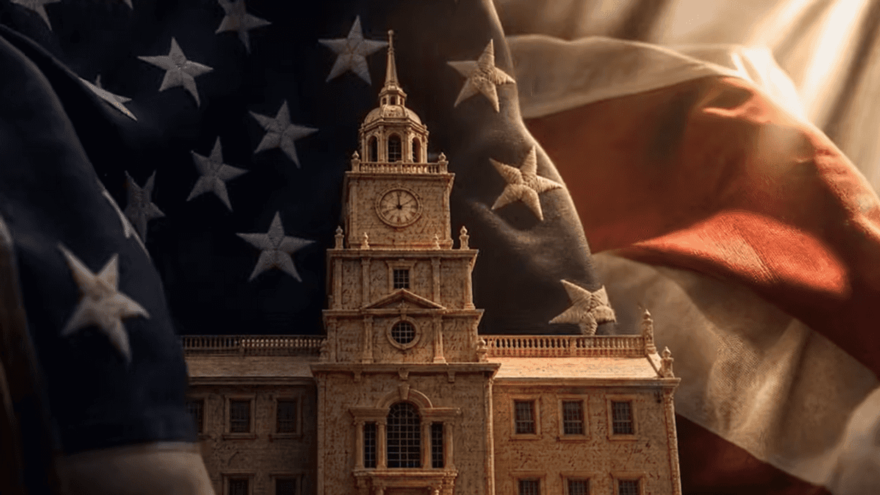 A model of Philadelphia's Independence Hall appears in front of an American flag