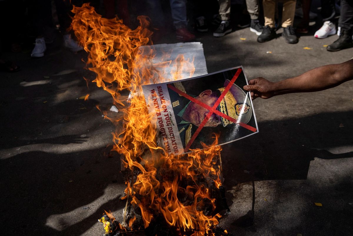 A Myanmar citizen living in India burns a poster of Myanmar's army chief Senior General Min Aung Hlaing with his face crossed out, during a protest organised by Chin Refugee Committee, against the military coup in Myanmar, in New Delhi, India, March 3, 2021.
