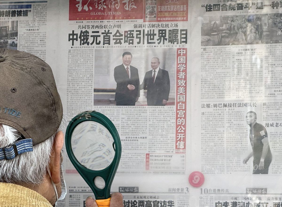 A newspaper shows Chinese President Xi Jinping and Russian President Vladimir Putin Shaking Hands