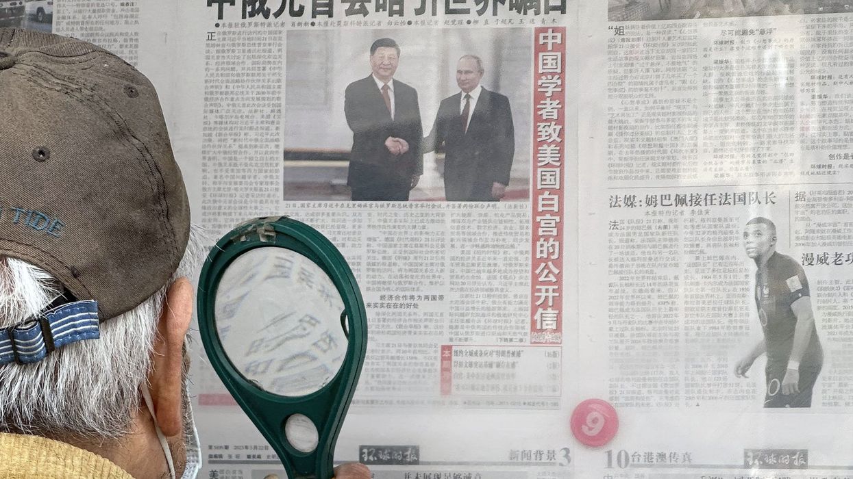 A newspaper shows Chinese President Xi Jinping and Russian President Vladimir Putin Shaking Hands