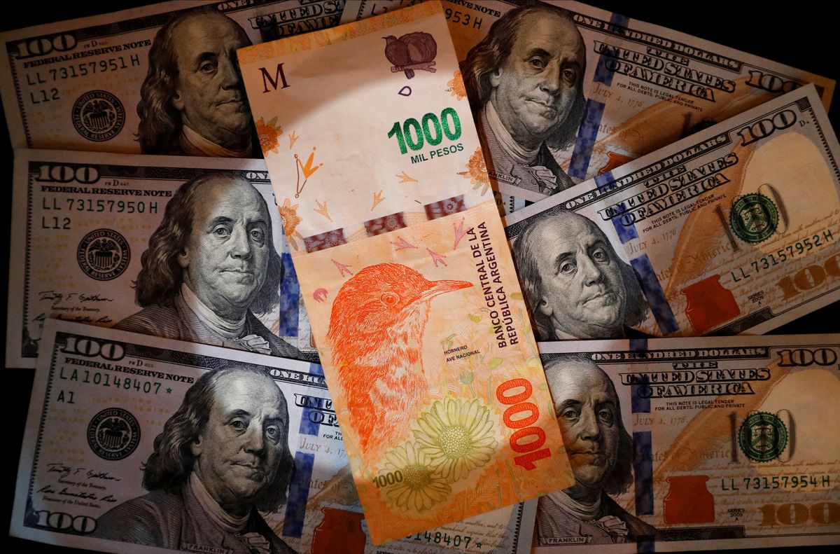  A one thousand Argentine peso bill sits on top of several one hundred U.S. dollar bills 