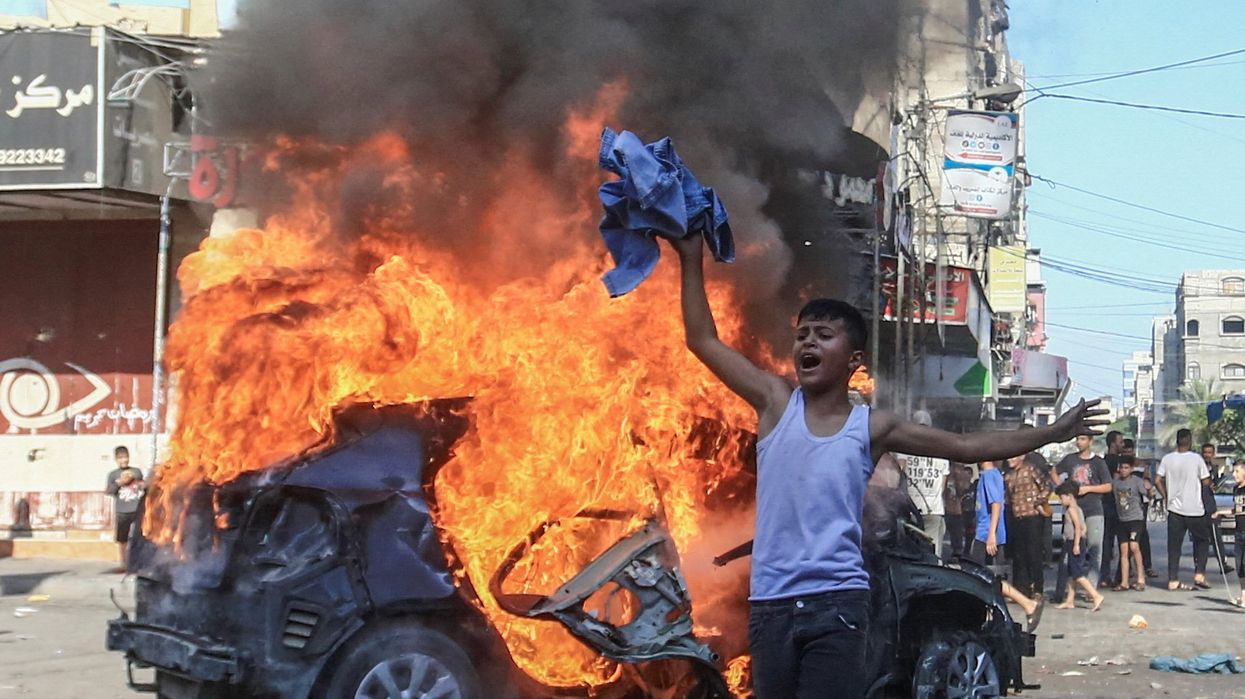 A Palestinian boy reacts next to a burning Israeli vehicle that Palestinian gunmen brought to Gaza after they infiltrated areas of southern Israel on Saturday.