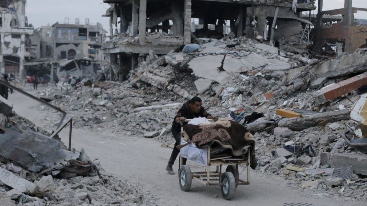 A Palestinian pushes belongings past the rubble of buildings and houses destroyed during the Israeli offensive, amid a ceasefire between Israel and Hamas, in Jabalia in the northern Gaza Strip, January 22, 2025.