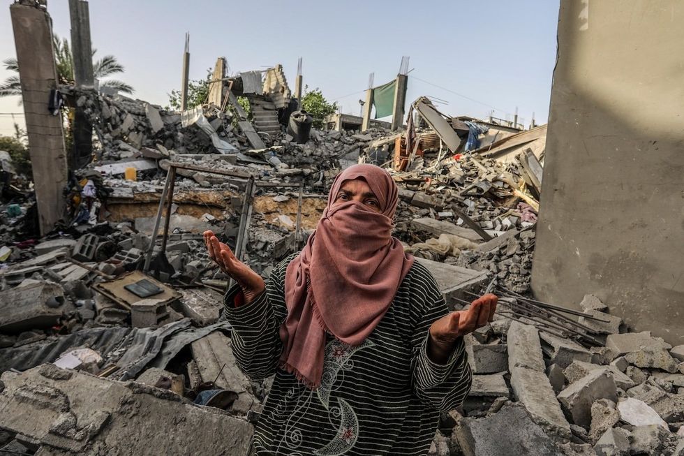 ​A Palestinian woman inspects a house that was destroyed after an Israeli airstrike in Rafah, April 24, 2024.