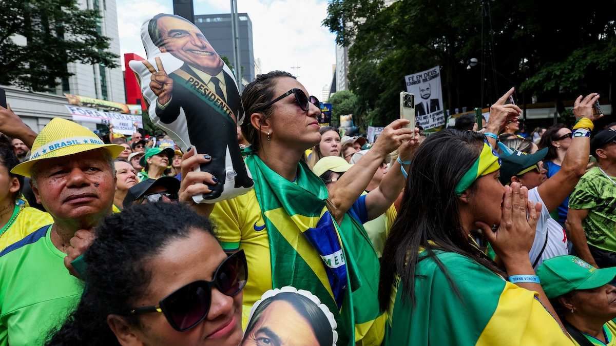 A person holds a depiction of former Brazilian President Jair Bolsonaro, as people gather on the day of a campaign rally of a pre-candidate of the right-wing Brazil's senator Flavio Bolsonaro, ahead of the presidential elections, in Sao Paulo, Brazil.