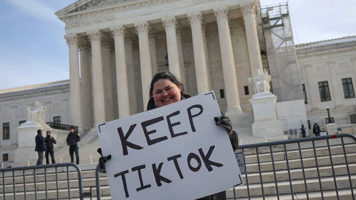 A person holds a placard on the day justices hear oral arguments in a bid by TikTok and its China-based parent company, ByteDance, to block a law intended to force the sale of the short-video app by Jan. 19 or face a ban on national security grounds, outside the U.S. Supreme Court, in Washington, U.S., January 10, 2025.