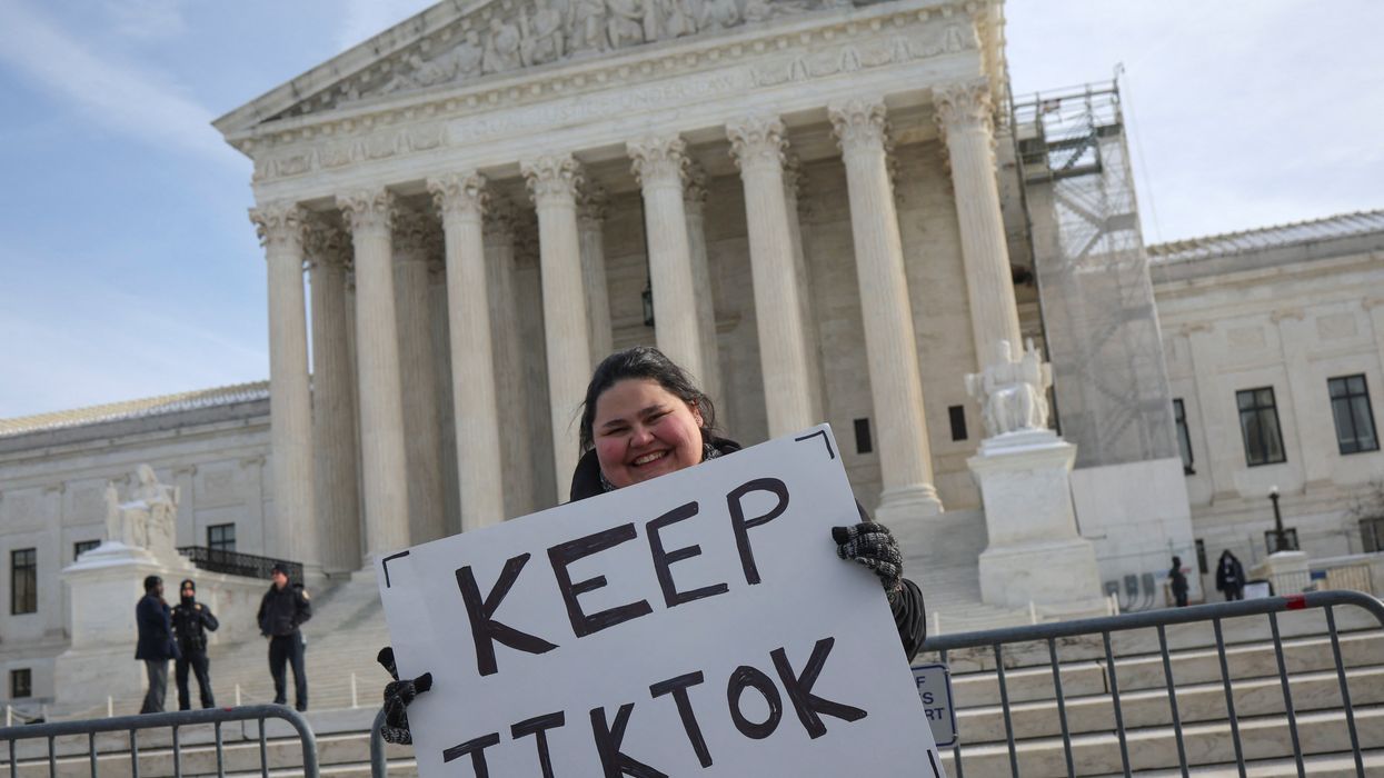 A person holds a placard on the day justices hear oral arguments in a bid by TikTok and its China-based parent company, ByteDance, to block a law intended to force the sale of the short-video app by Jan. 19 or face a ban on national security grounds, outside the U.S. Supreme Court, in Washington, U.S., January 10, 2025.