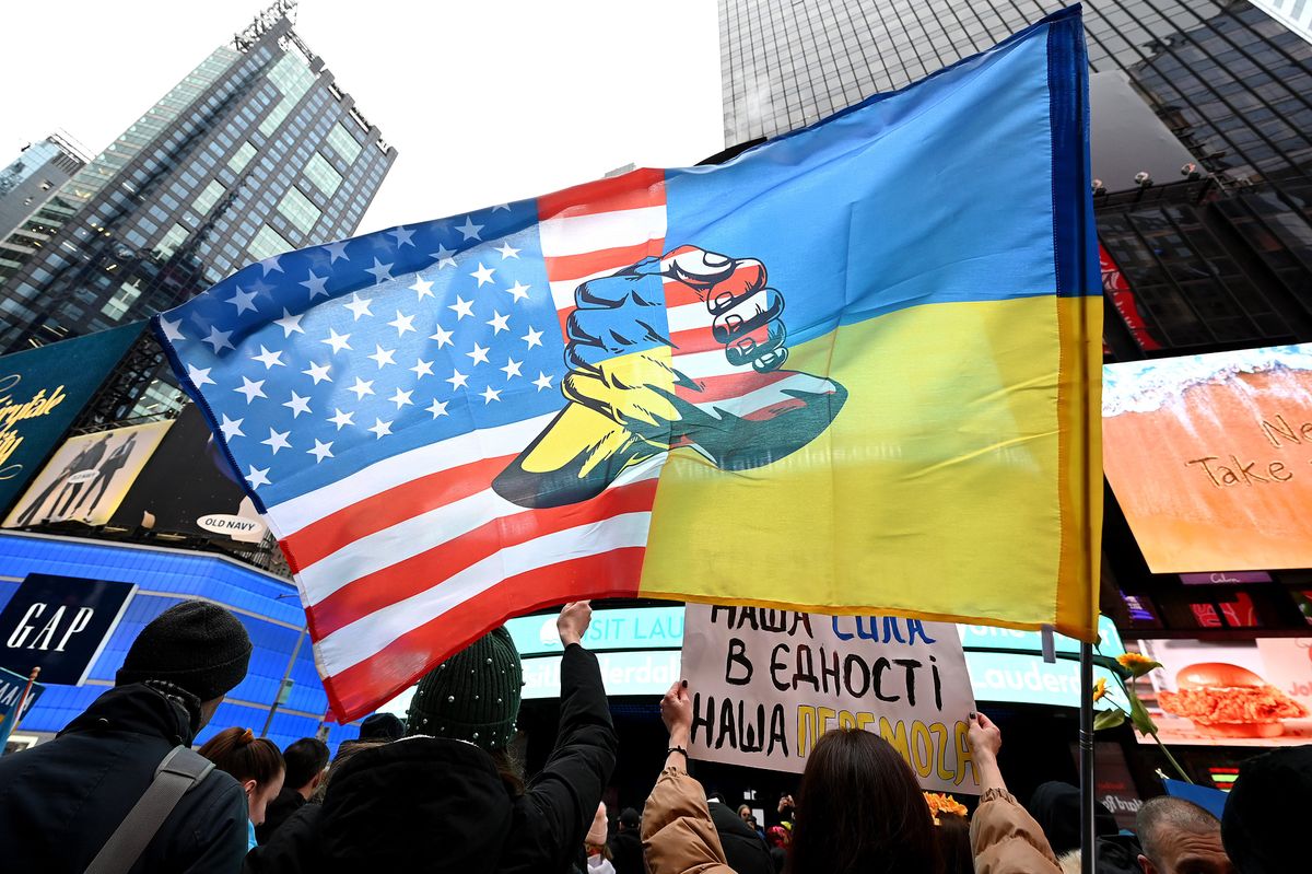 A person holds up a double flag of Ukraine and the US at a rally in Times Square in New York to mark the one-year anniversary of Russia's invasion.