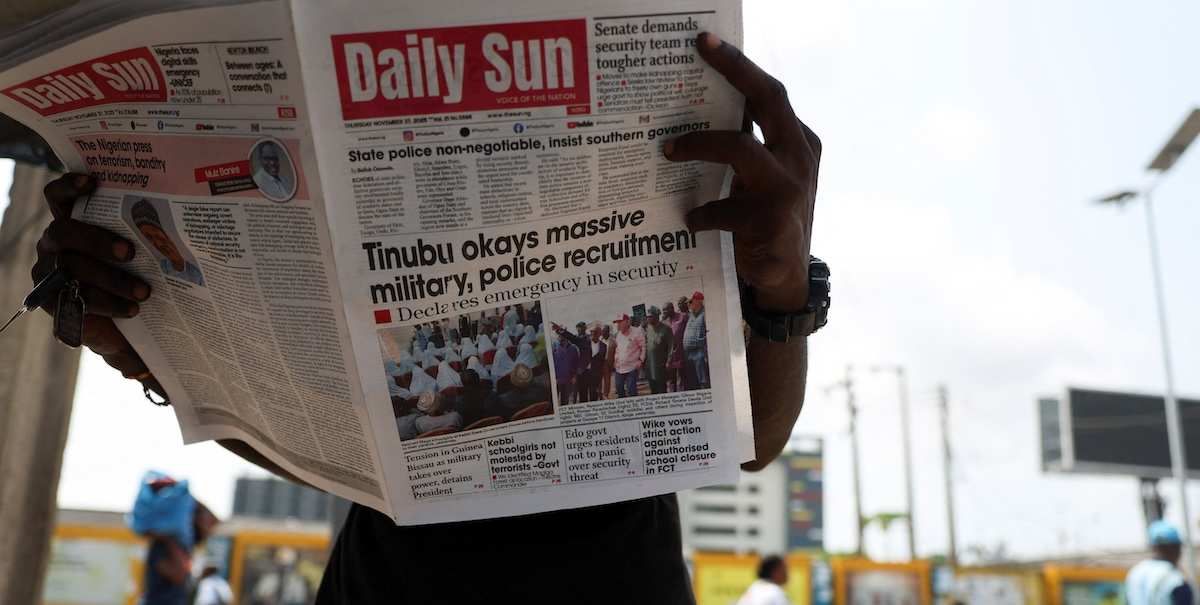 ​A person reads a newspaper at a roadside newspaper stand in Ikoyi Lagos, Nigeria, November 27, 2025. 