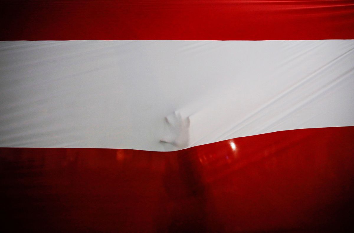 A person touches Peru's national flag after Francisco Sagasti from the Centrist Morado Party was elected Peru's interim president by Congress, in Lima