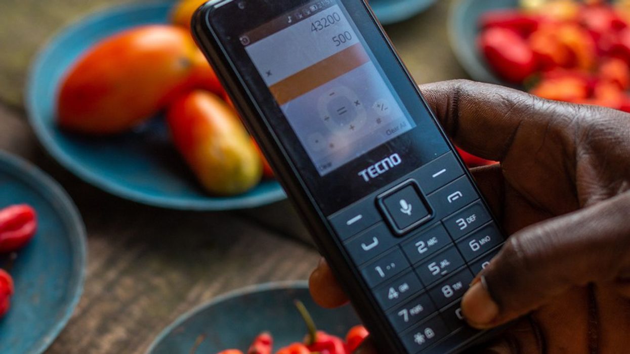 A person using the calculator on an old mobile phone