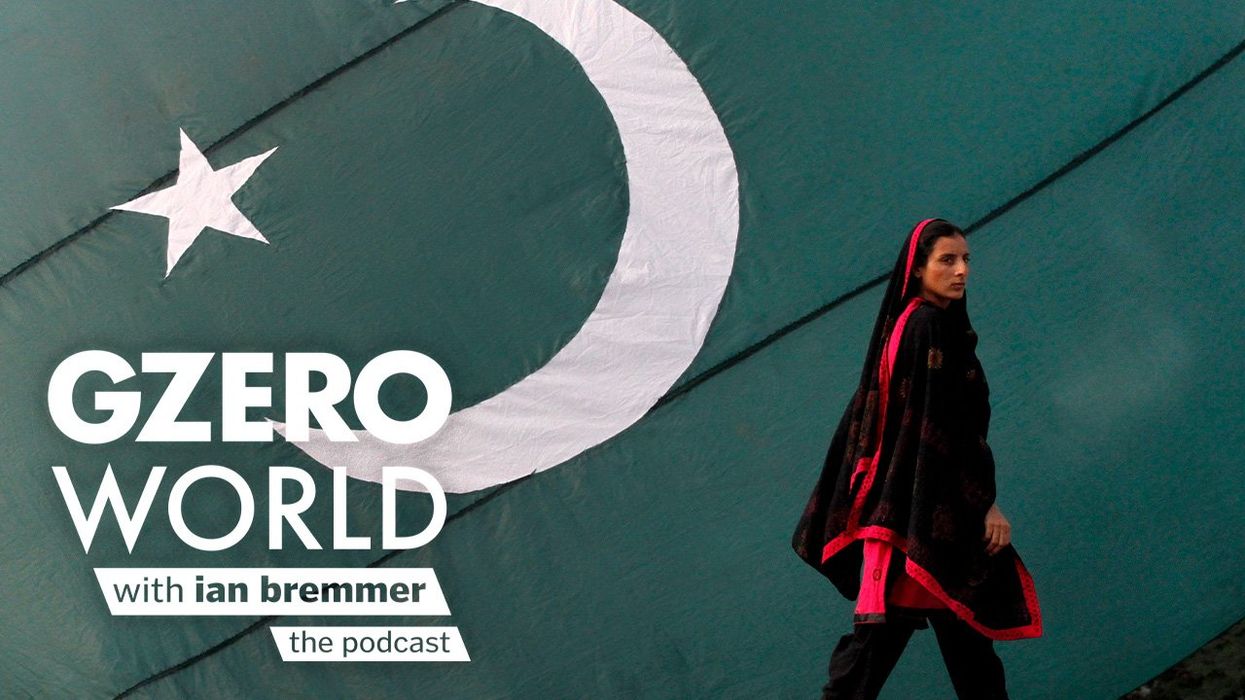 A photo of a woman walking in front of Pakistan flag with GZERO World Podcast logo superimposed on top.
