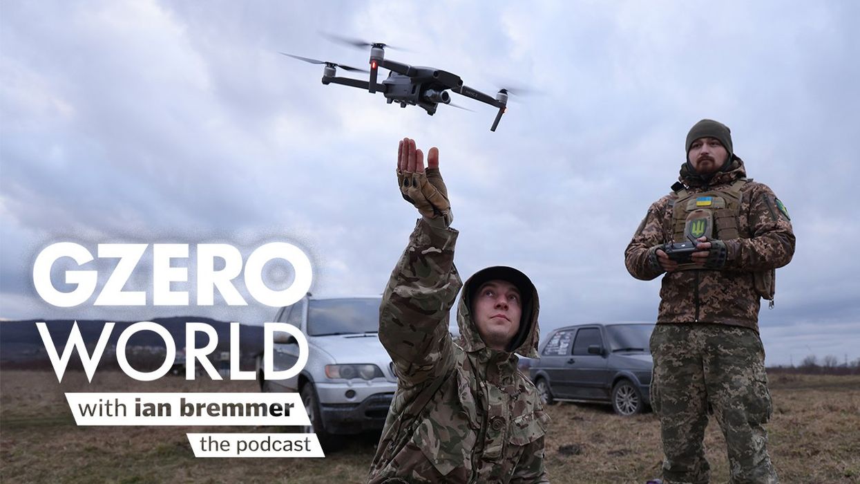 A photo of two Ukrainian soldiers launching a drone with the GZERO World Podcast logo superimposed on top.