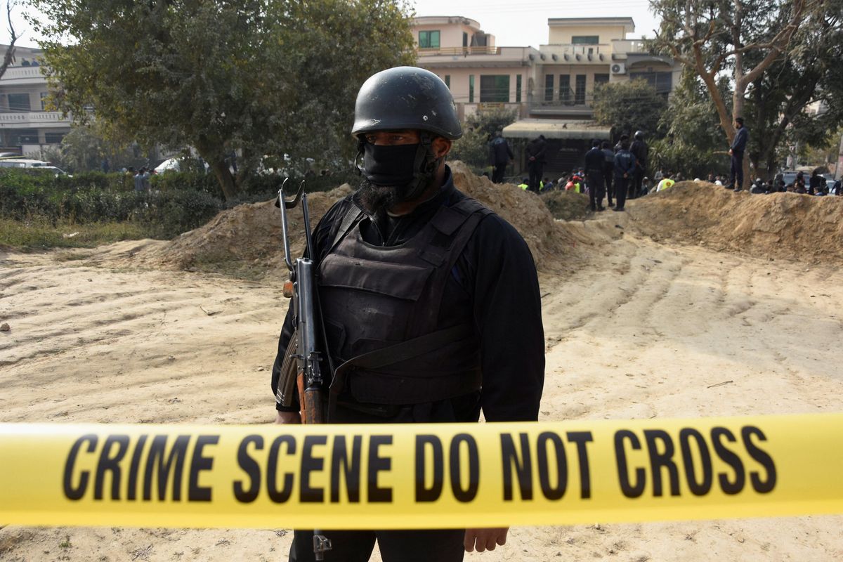 A police officer stands inside a cordoned-off area after a suicide car bombing in Islamabad, Pakistan.