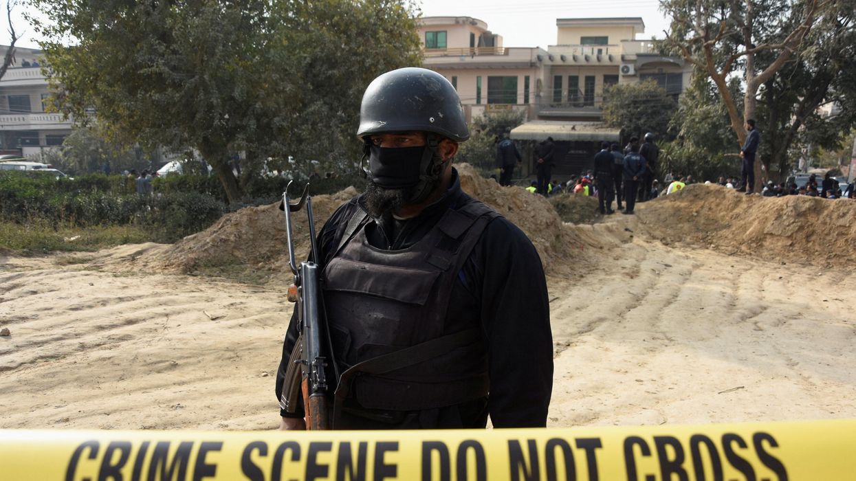 A police officer stands inside a cordoned-off area after a suicide car bombing in Islamabad, Pakistan.