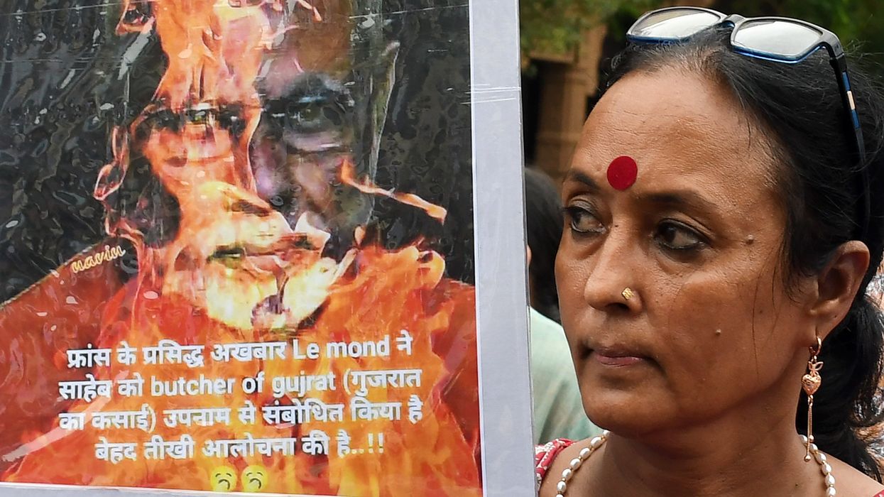 A protester holds a placard showing an image of burning PM Narendra Modi during a demonstration against the Manipur violence in Mumbai, India.