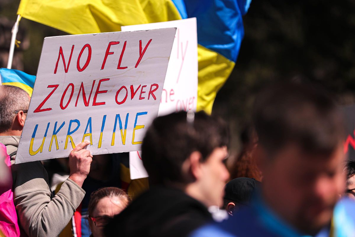 A protester holds up a sign calling for NATO to create a no-fly zone over Ukraine.