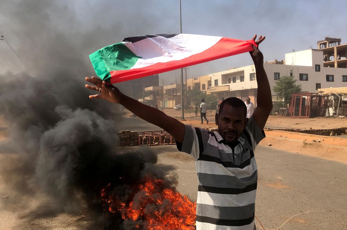 A protester waves a flag during what the information ministry calls a military coup in Khartoum, Sudan, October 25, 2021