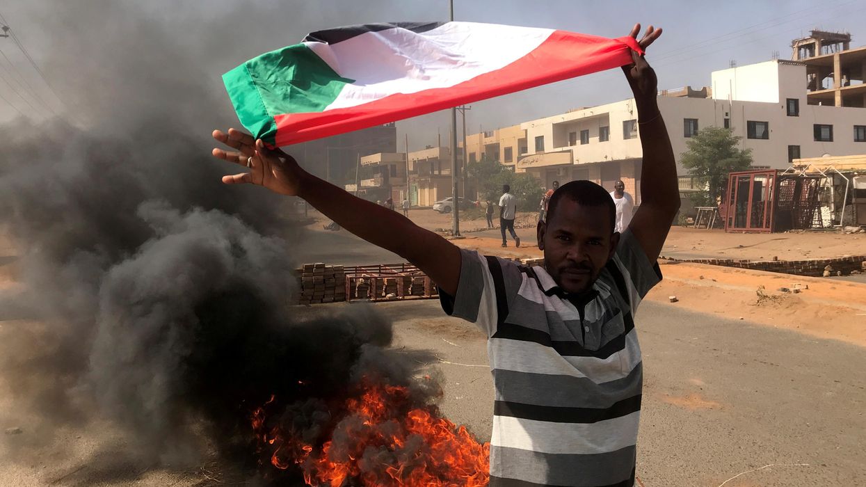 A protester waves a flag during what the information ministry calls a military coup in Khartoum, Sudan, October 25, 2021