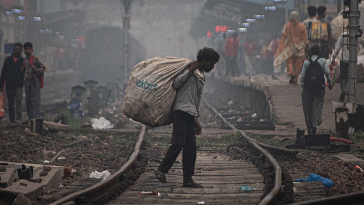 A ragpicker searches for garbage as he walks through railway tracks on a smoggy morning in New Delhi, India on November 4, 2023.