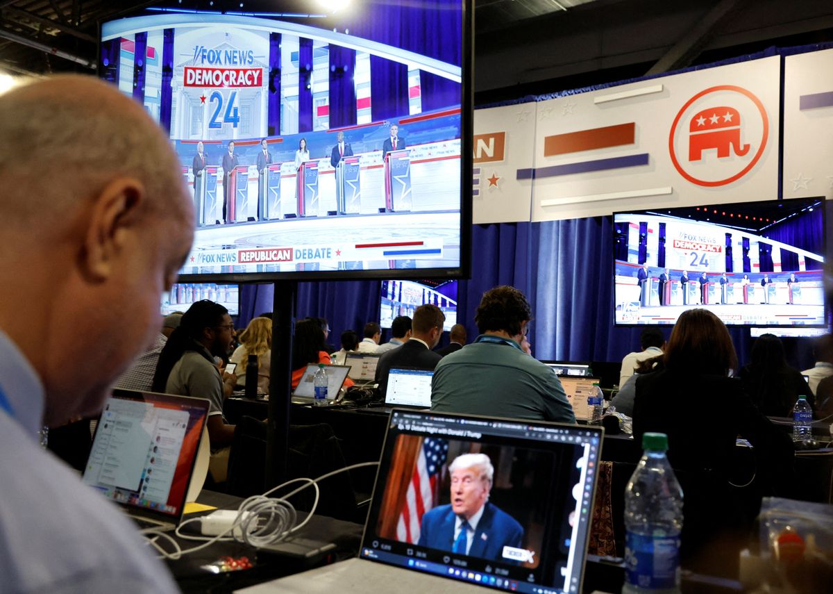 A reporter watches former President Donald Trump's online interview during the first Republican candidates' debate of the 2024 U.S. presidential campaign.