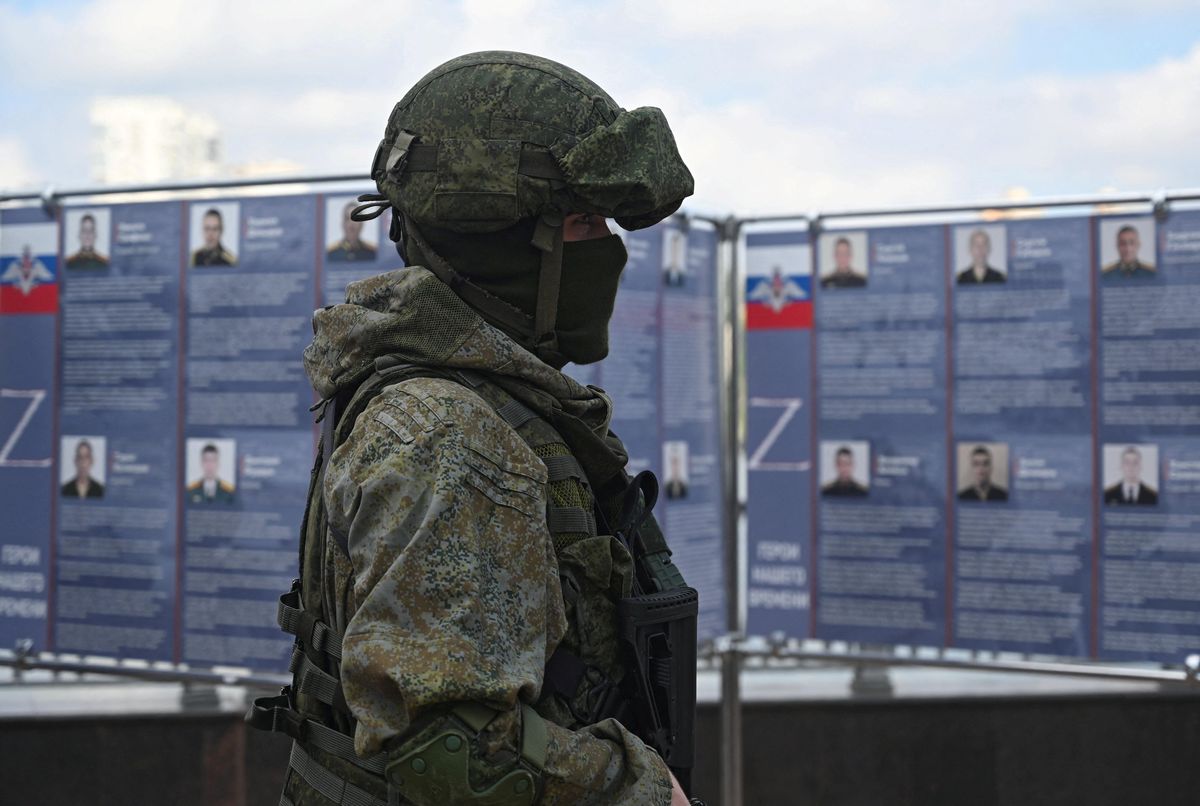 A Russian service member stands next to a mobile recruitment center for military service under contract in Rostov-on-Don.