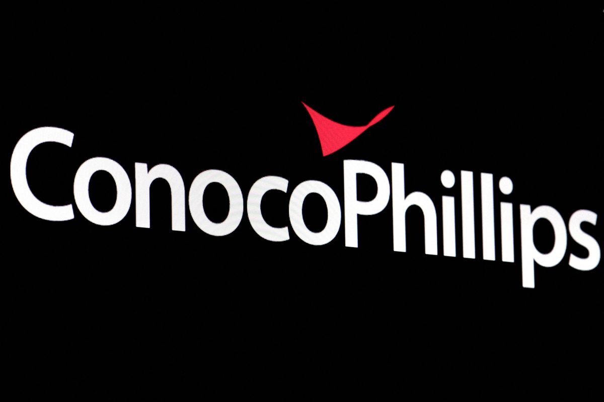 A screen displays the logo for ConocoPhillips on the floor of the New York Stock Exchange.