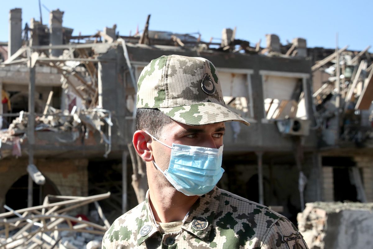 A serviceman examines a residential area of the city damaged in a rocket attack in Ganja, Azerbaijan on 11 October