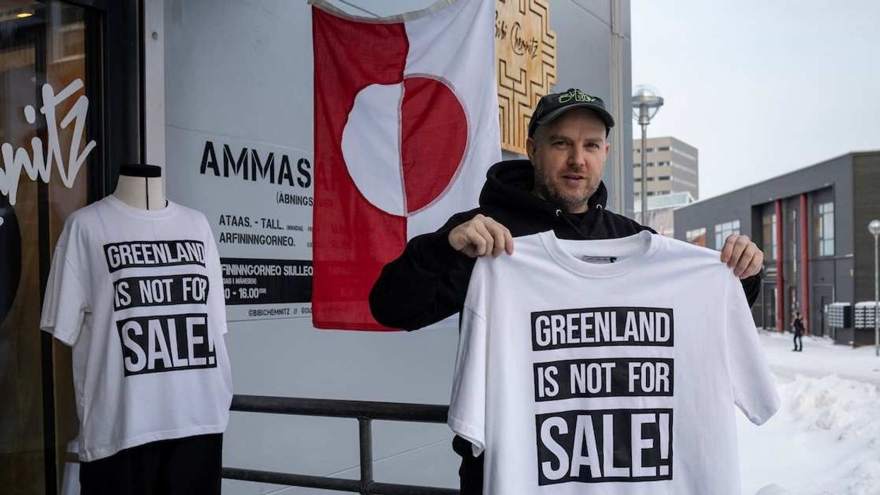 A shop owner David Rogilds holds a shirt that he sells in Nuuk, Greenland, January 14, 2026.