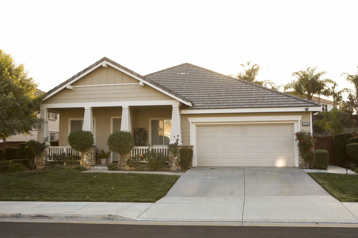 A single family house with a driveway viewed from the street