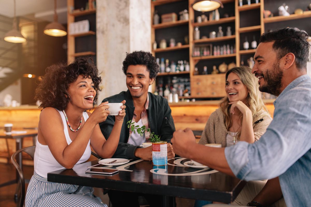 A small group of people sitting at a restaurant table, smiling.