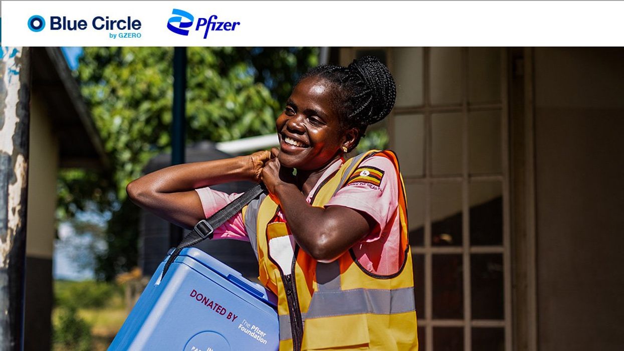 A smiling female community health worker in Uganda carries a COVID vaccine kit donated by the Pfizer Foundation