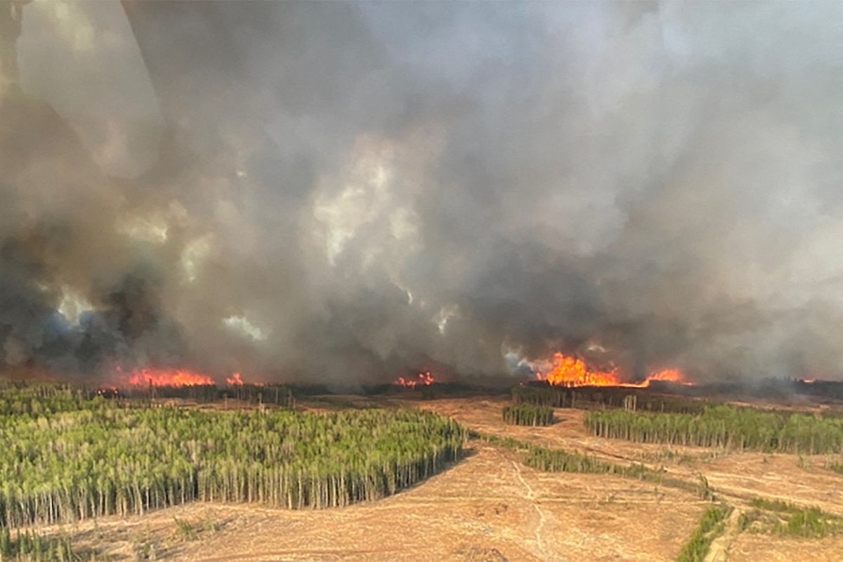 A smoke column rises from wildfires near Fox Creek in Alberta, Canada.