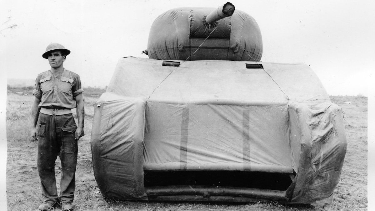 A soldier stands next to a dummy tank in May 1944.