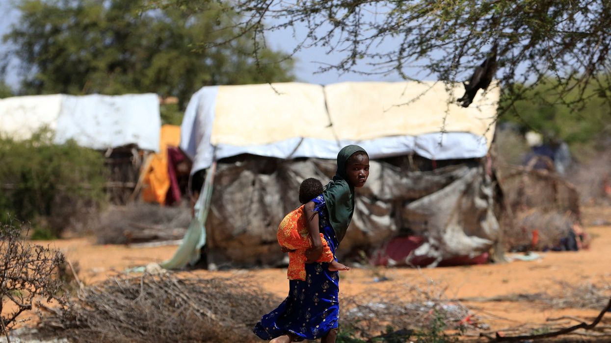 A Somali refugee girl carries her sibling in the Hagadera refugee camp near the Kenya-Somalia border, in Garissa County, Kenya, January 17, 2023.