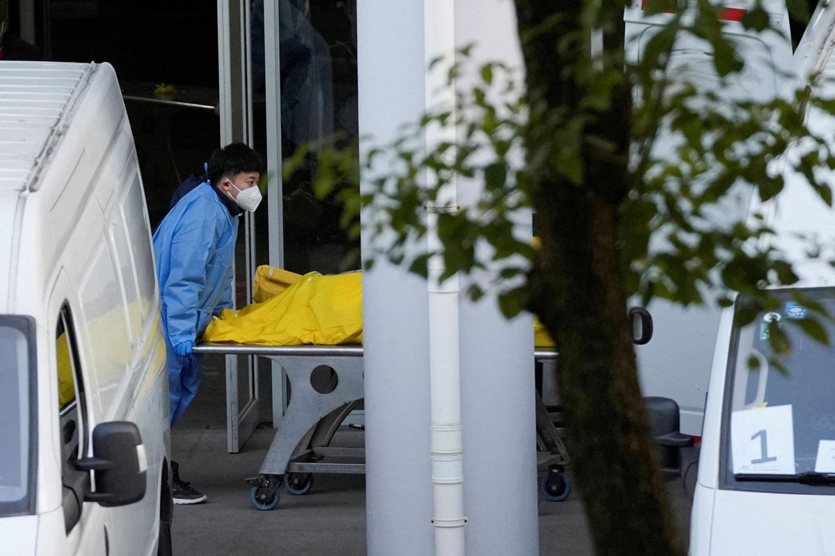 A staff member pushes a cart carrying a body bag at a funeral home in Shanghai, China.