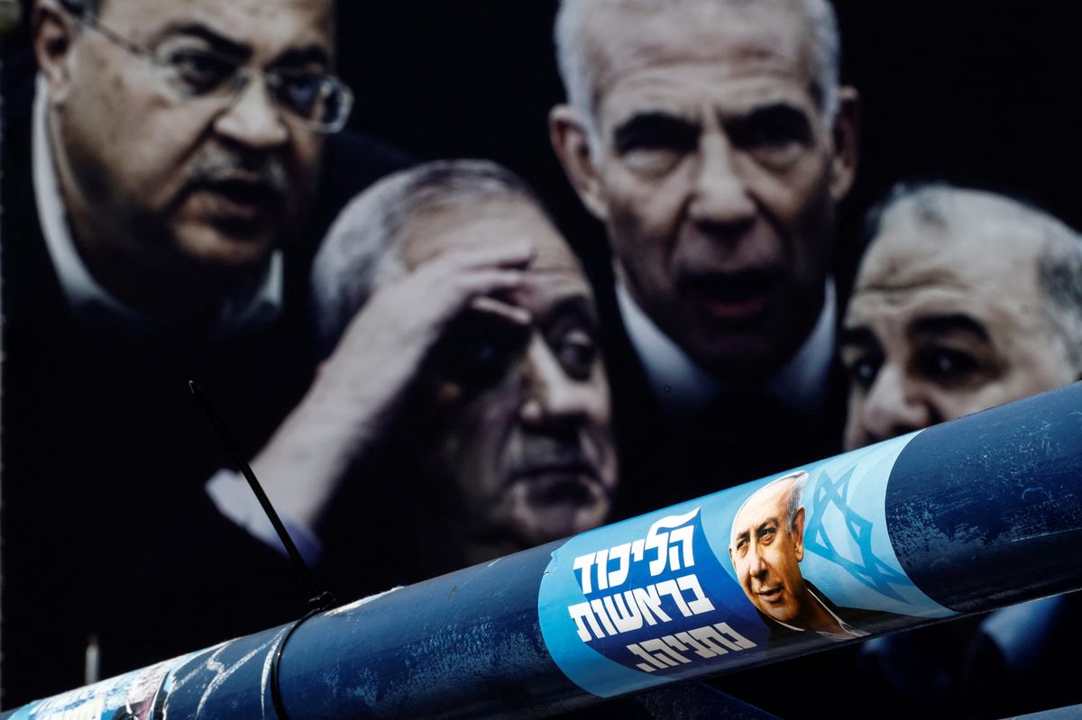 ​A sticker and a banner of election campaign, depicting former Israeli Prime Minister Benjamin Netanyahu and other politicians, are seen in Tel Aviv.