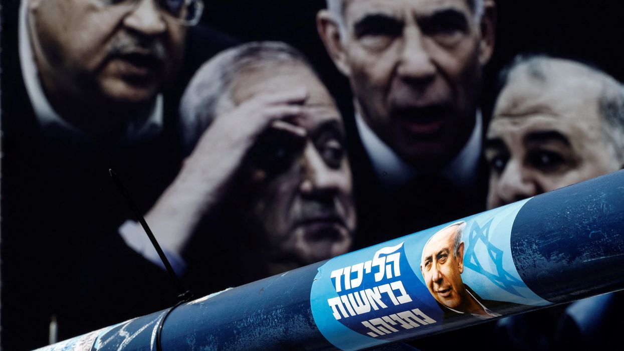 A sticker and a banner of election campaign, depicting former Israeli Prime Minister Benjamin Netanyahu and other politicians, are seen in Tel Aviv.