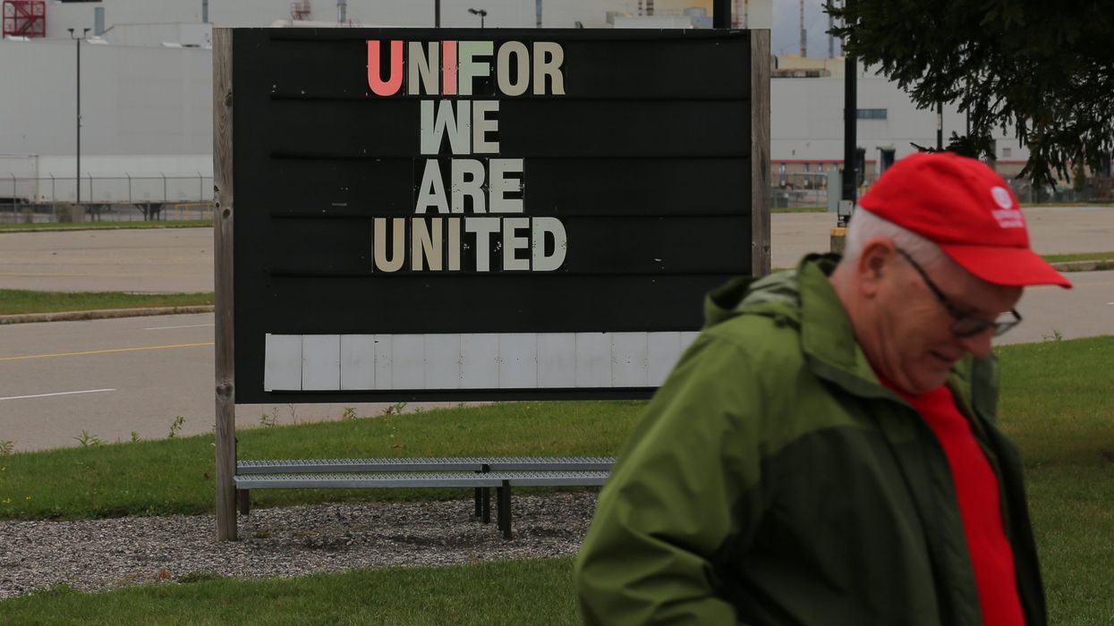 A striking member of the union Unifor walks to a picket line